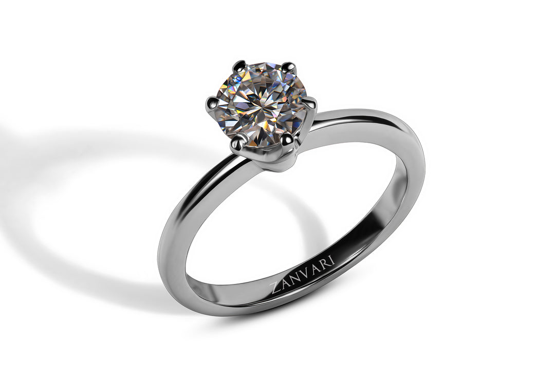 An sterling silver solitaire ring featuring a prong-set, round-cut moissanite an alternative for  diamond with a shadow cast on a white background.