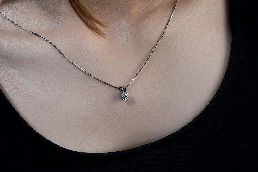 A model with a black top wearing delicate moissanite pendant with Italian boxed chain  made in 925 silver