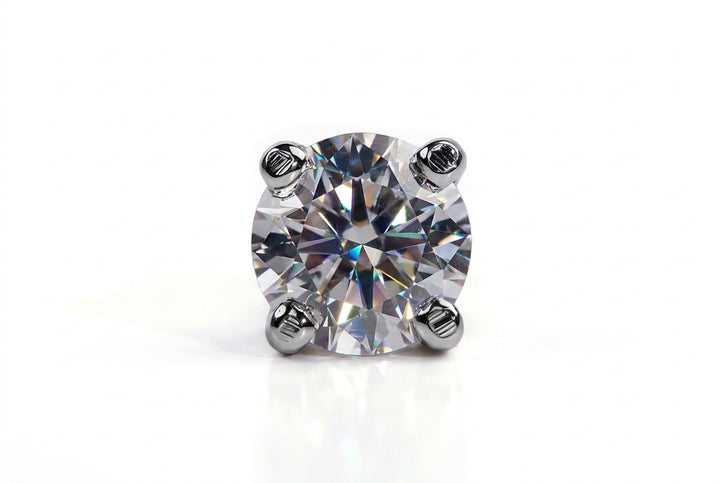 Direct front-view studio shot of a brilliant-cut round diamond stud secured with four silver prongs on a seamless white background.