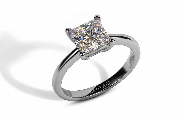 A princess-cut moissanite engagement ring in a polished silver-colored metal band, featuring an engraved brand name 'ZANVARI' on the inside of the band, set against a clean white background with a soft shadow.