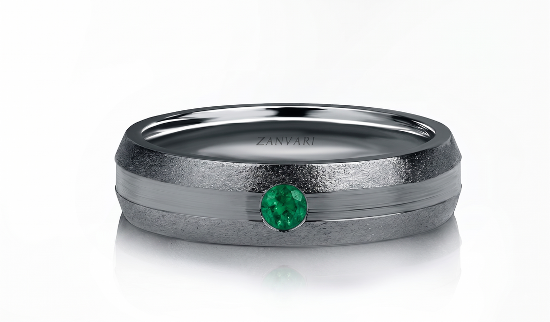 A ZANVARI ring featuring a textured matte gray band with a polished silver center channel and a round-cut green emerald gemstone, shown on a clean white background.