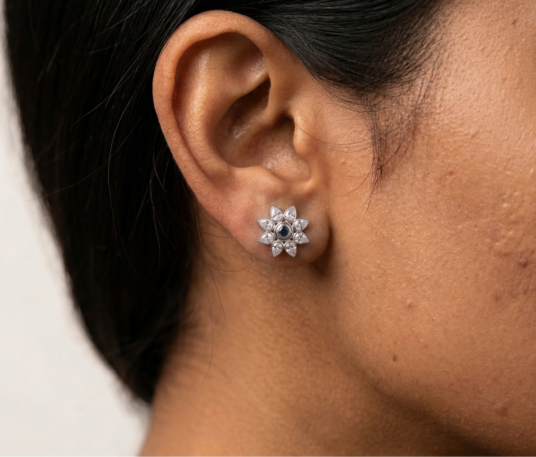 Close-up of an ear wearing a diamond earring with a light background