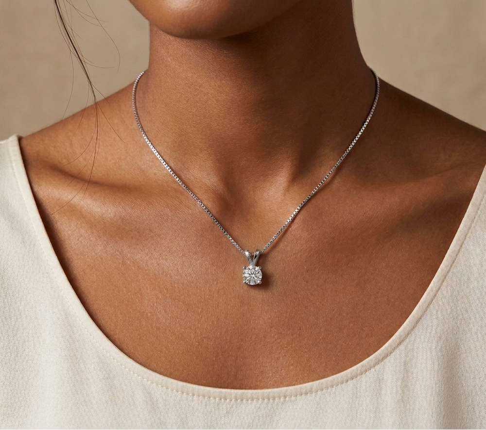 Necklace with a moissanite pendant worn by a person against a neutral background