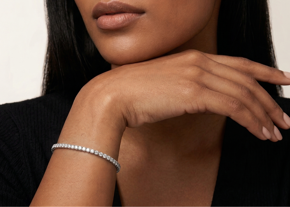 Close-up of a woman wearing a silver bracelet on a neutral background
