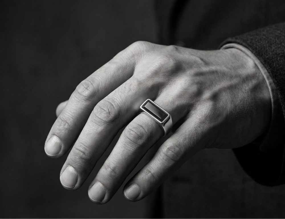 Close-up of a hand wearing a agate ring on a dark background