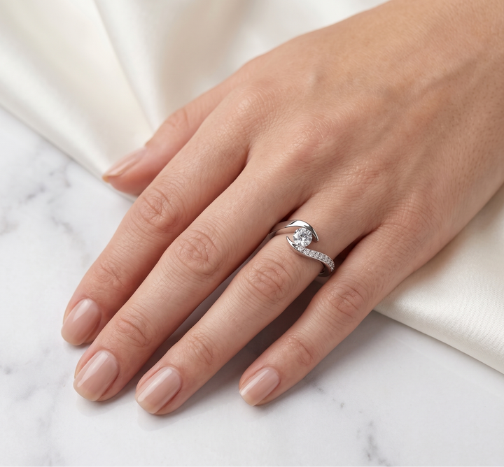 Hand wearing a moissanite  ring on a marble surface