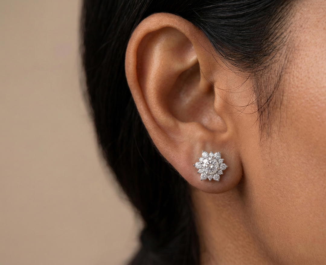 Close-up of an ear wearing a moissanite
 stud earring with a neutral background