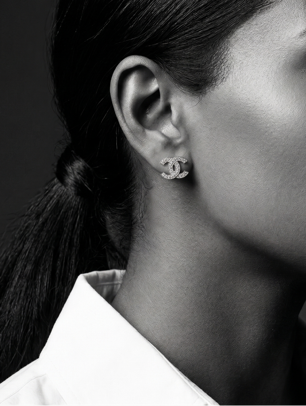 Black and white portrait of a woman wearing earrings with a blurred background