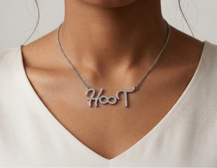 Necklace with 'name engraved personalised' pendant worn by a person against a neutral background