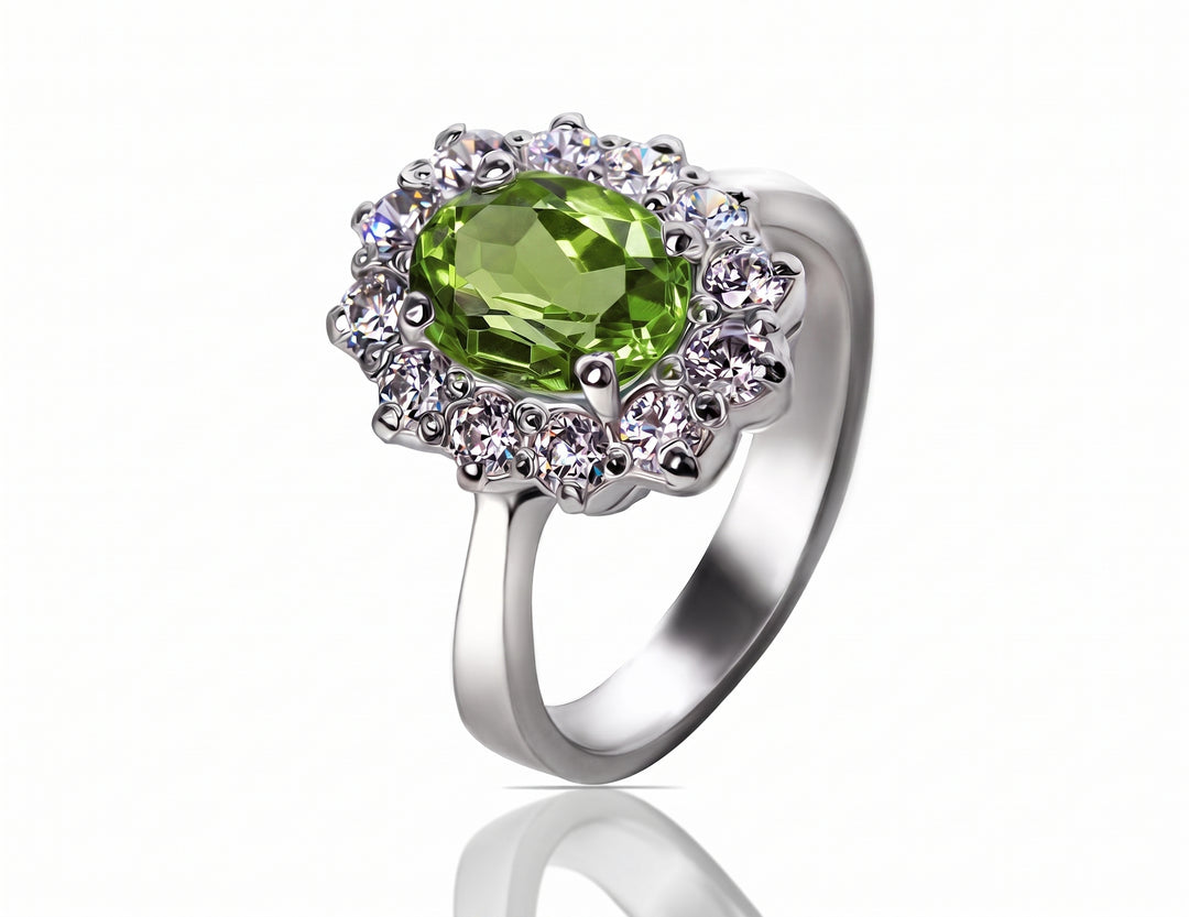 An oval peridot ring with a halo of clear stones, set in a polished silver-colored band, shown on a white background with a soft reflection.