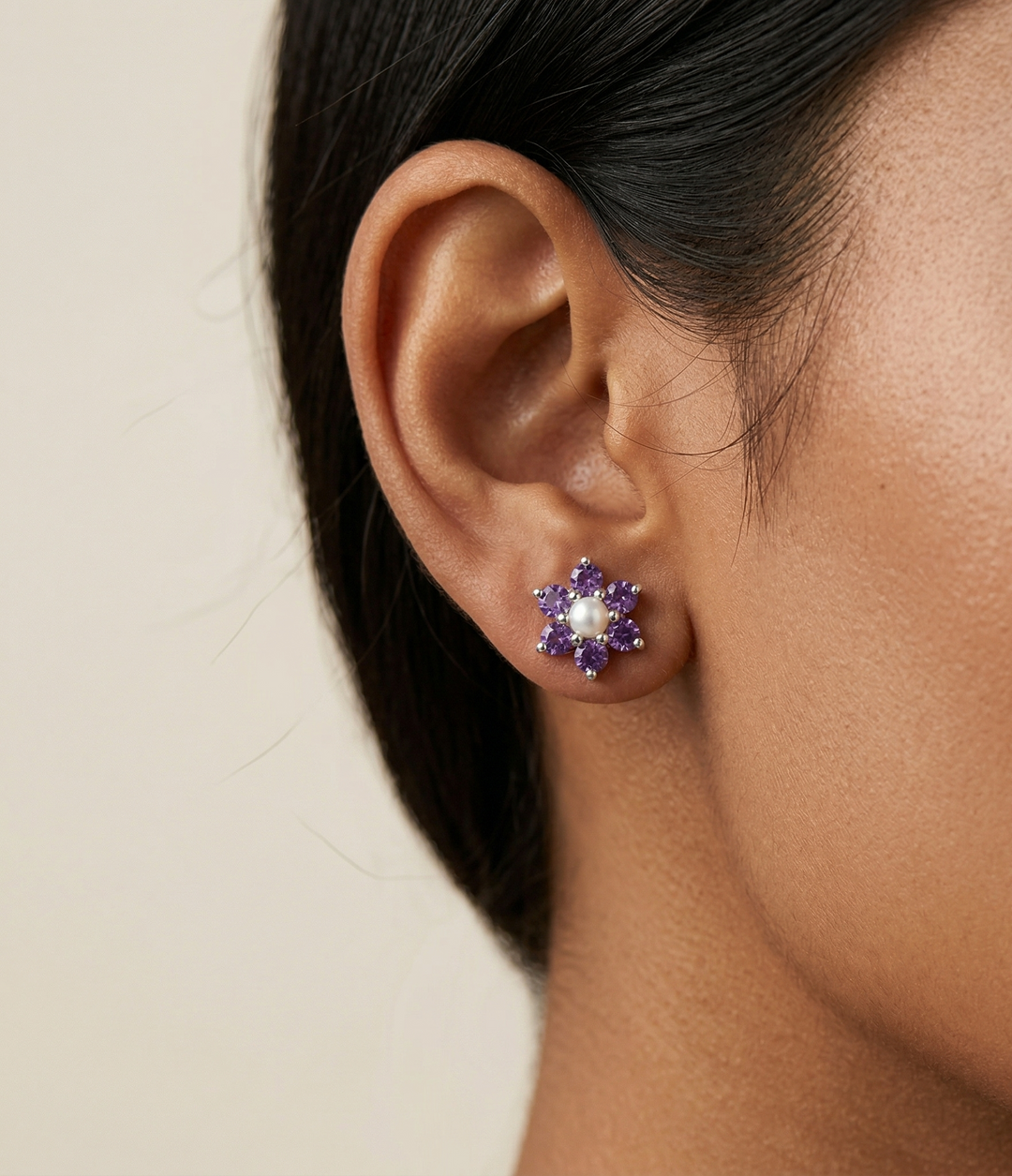 Model wearing Violet Crown Studs by Zanvari Pakistan — natural amethyst and pearl flower earrings in 925 sterling silver on the ear.