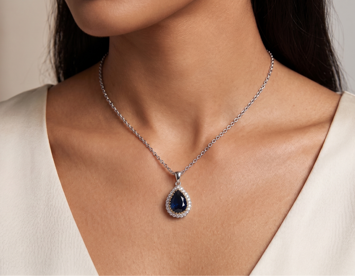 Woman wearing a necklace with a blue pendant
