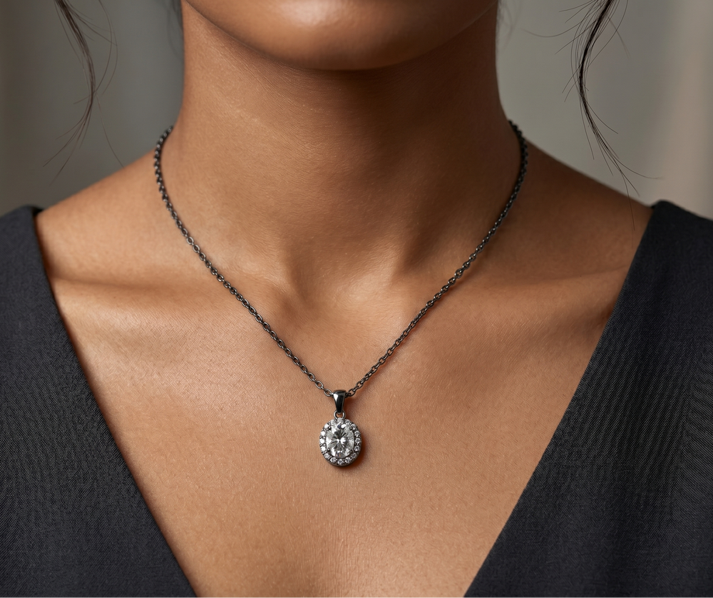 Necklace with a oval cut moissanite in silver worn by a model against a neutral background
