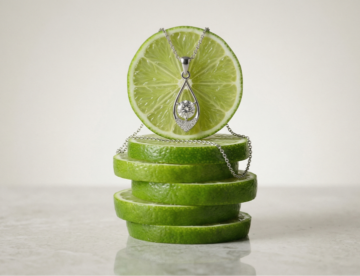Necklace on a stack of sliced limes with a white background
