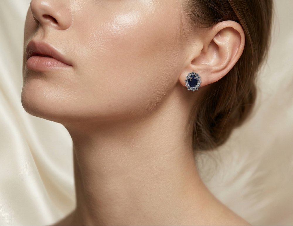 Close-up of a woman wearing a blue gemstone earring against a neutral background