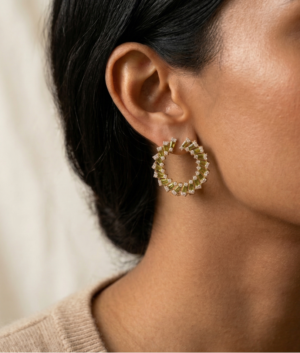 Close-up of a woman wearing gold hoop earrings with a neutral background