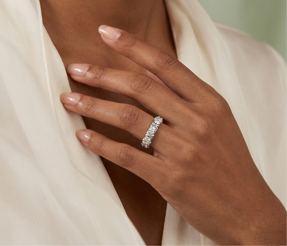 Hand wearing a diamond ring with a soft background