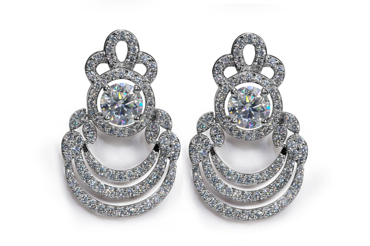 Luxury pavé diamond-style drop earrings with round center stone and layered arc design in white metal finish