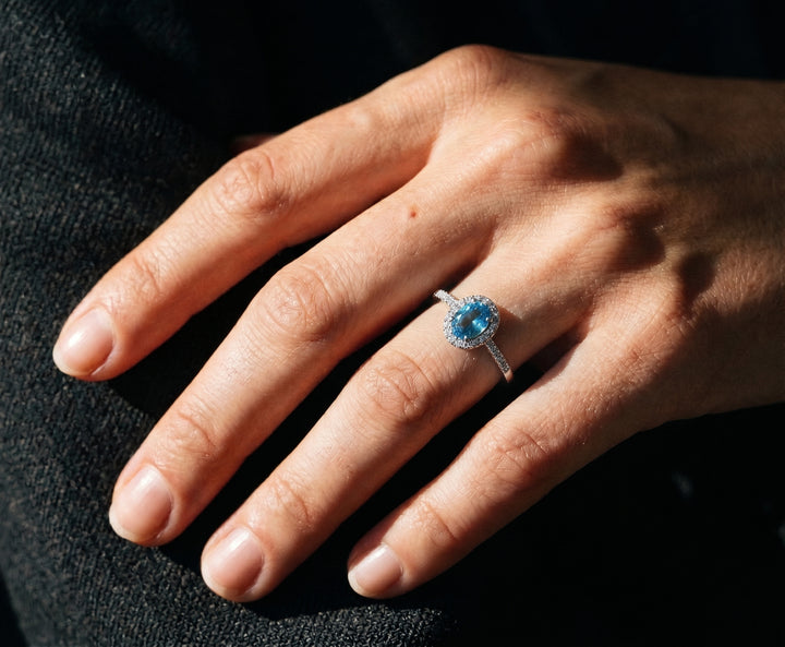 Hand wearing 925 silver halo topaz ring