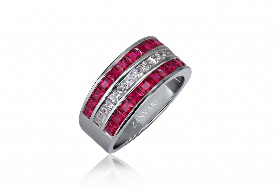 A silver-toned band ring featuring two rows of faceted gemstones: a vibrant pinkish-red row and a clear white row. The brand name 'ZANVARI' is engraved on the inside of the band.