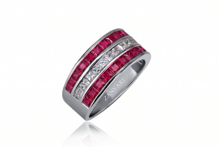 A silver-toned band ring featuring two rows of faceted gemstones: a vibrant pinkish-red row and a clear white row. The brand name 'ZANVARI' is engraved on the inside of the band.