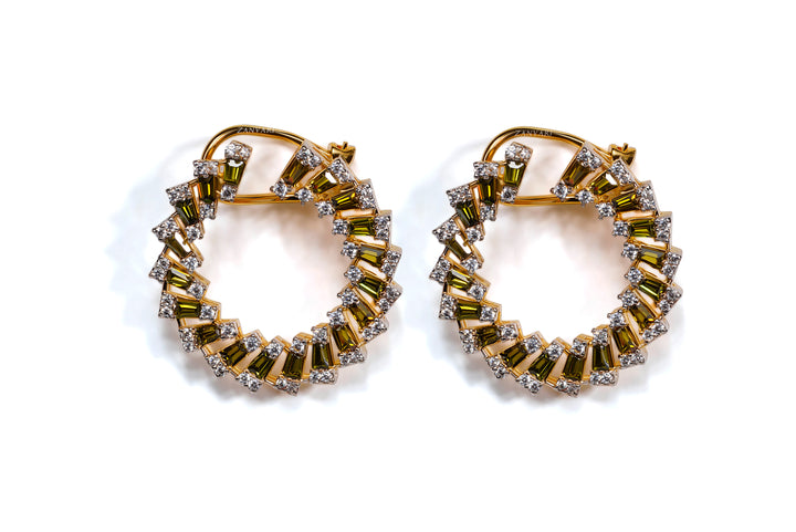 A pair of gold-plated hoop earrings with radiant sunburst designs, adorned with green and white lab-made stones and cubic zirconia accents.