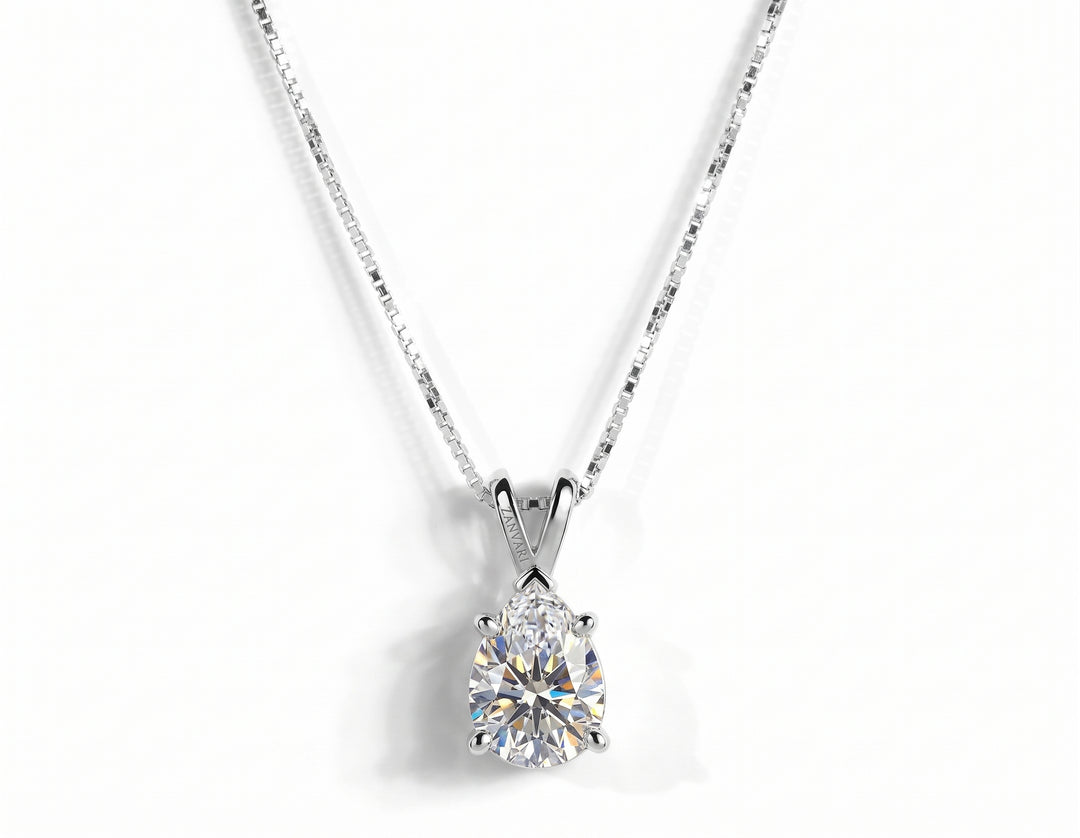 A pear-cut diamond pendant necklace in a silver four-prong setting on a silver box chain, isolated on a white background.