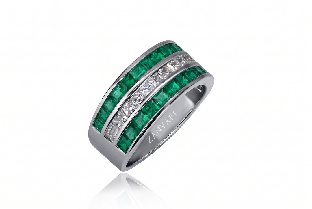 A silver band ring featuring two rows of green emerald-cut gemstones and clear pavé-set stones, with the brand name ZANVARI engraved on the inside, shown on a white background with a soft reflection.