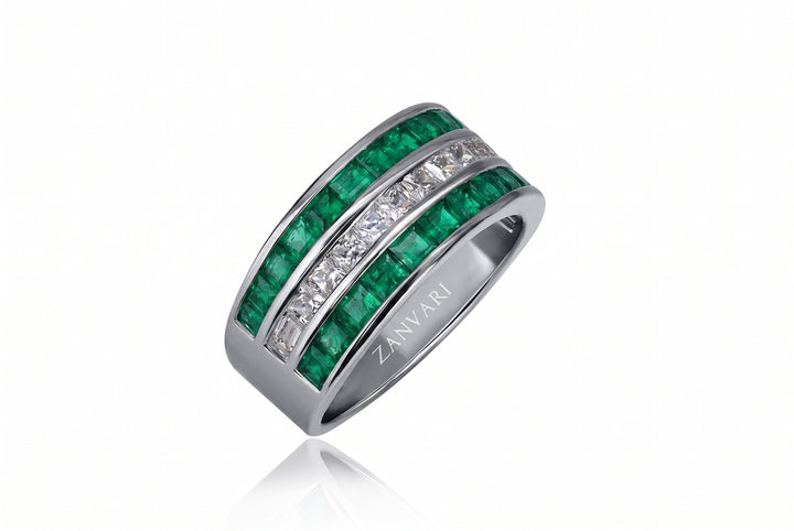 A silver band ring featuring two rows of green emerald-cut gemstones and clear pavé-set stones, with the brand name ZANVARI engraved on the inside, shown on a white background with a soft reflection.