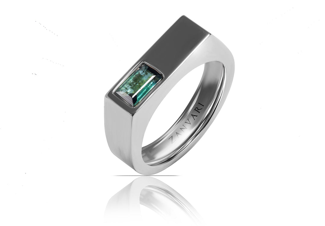 A silver-toned rectangular ring featuring a baguette-cut tourmaline green gemstone, shown on a clean white background with a soft reflection below.