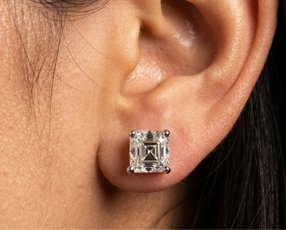 Close-up of an ear wearing a moissanite asscher cut  stud earring.