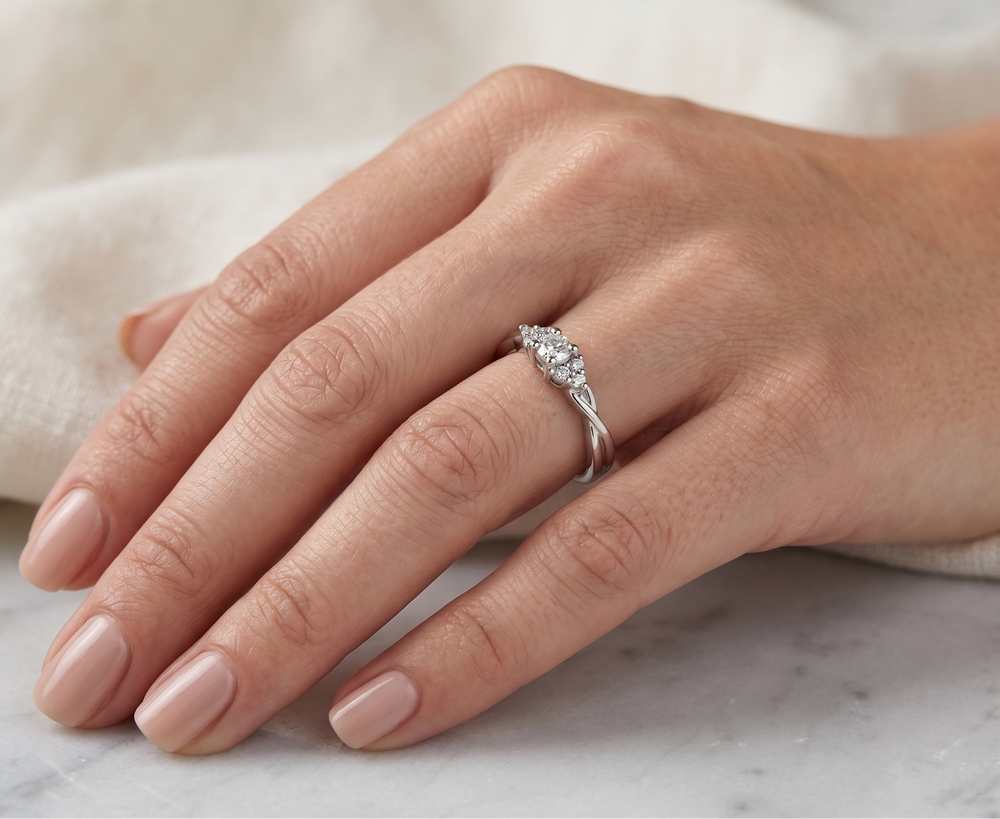 Hand wearing a moissanite ring on a marble surface