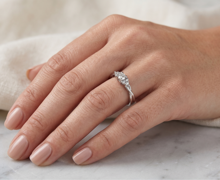 Hand wearing a moissanite ring on a marble surface