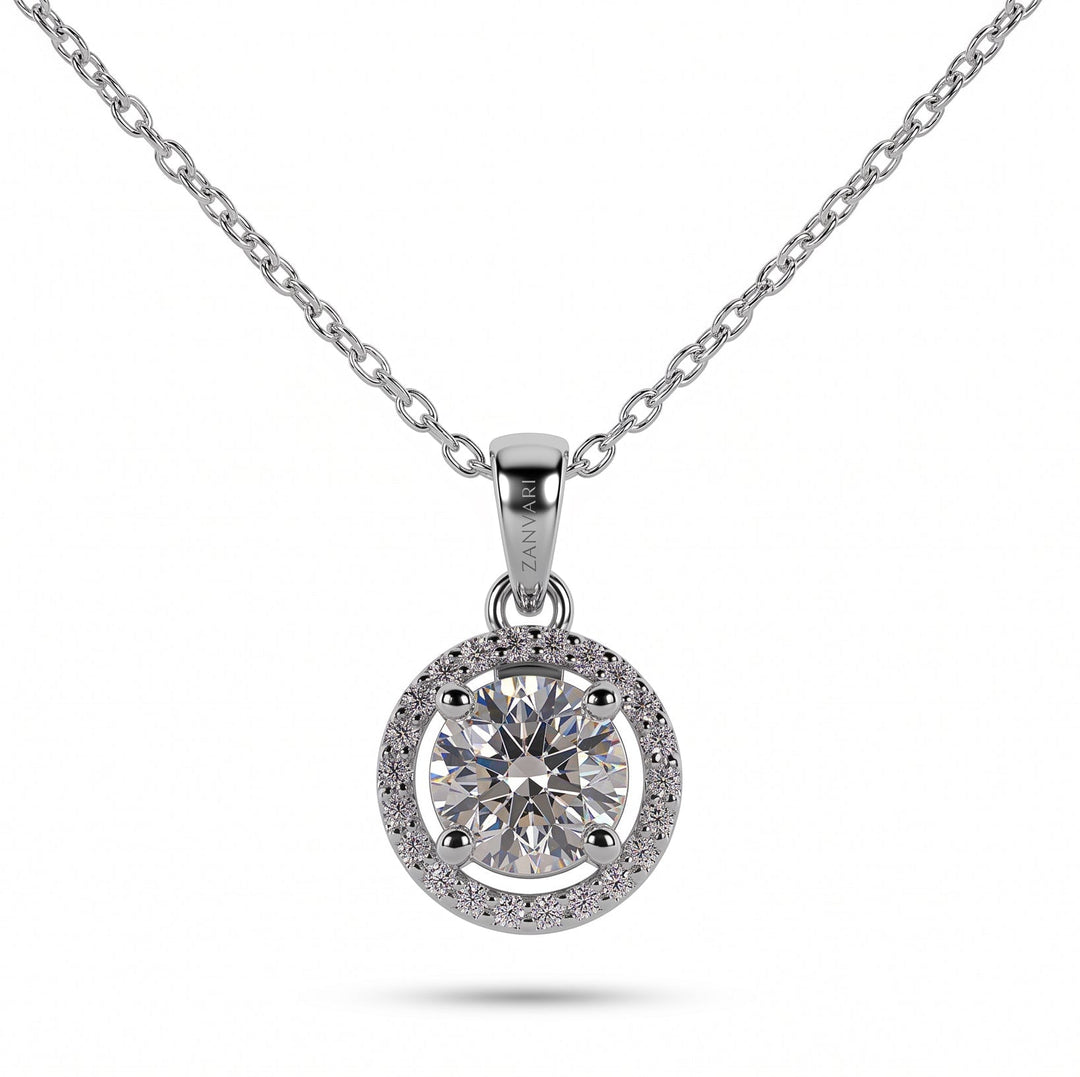A silver-toned moissanite necklace with a round halo pendant and a central round-cut diamond, shown on a clean white background.