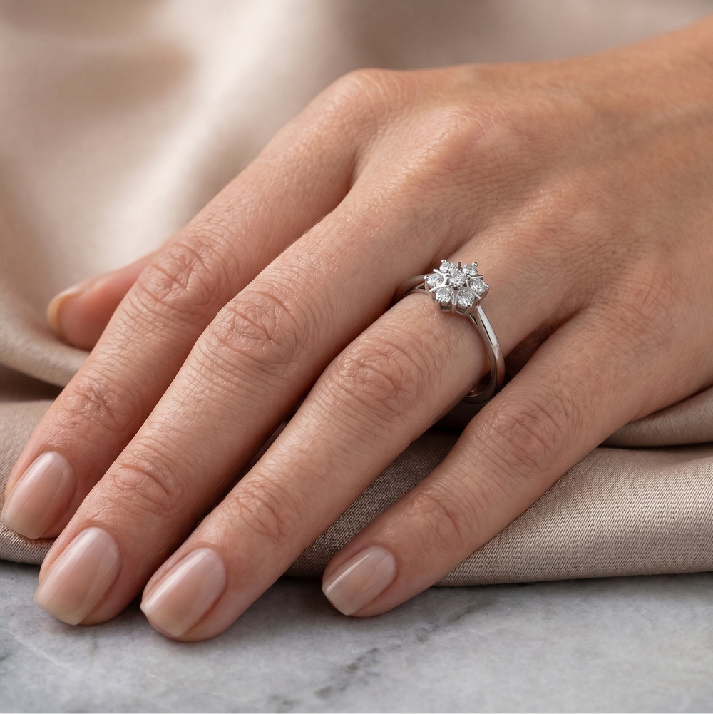 Hand wearing a floral moissanite ring on a neutral background