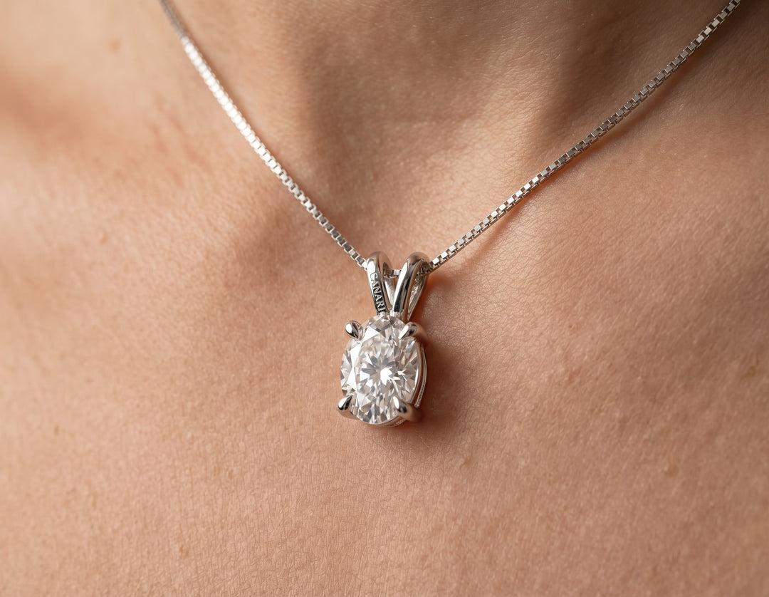Model wearing the Truly Mine Necklace, a 1ct oval moissanite pendant hanging lengthwise on an 16-inch silver box chain