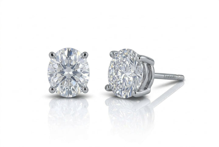 Pair of brilliant oval-cut lab-grown diamond stud earrings set in a four-prong white gold basket setting, shown against a white background with soft reflections.