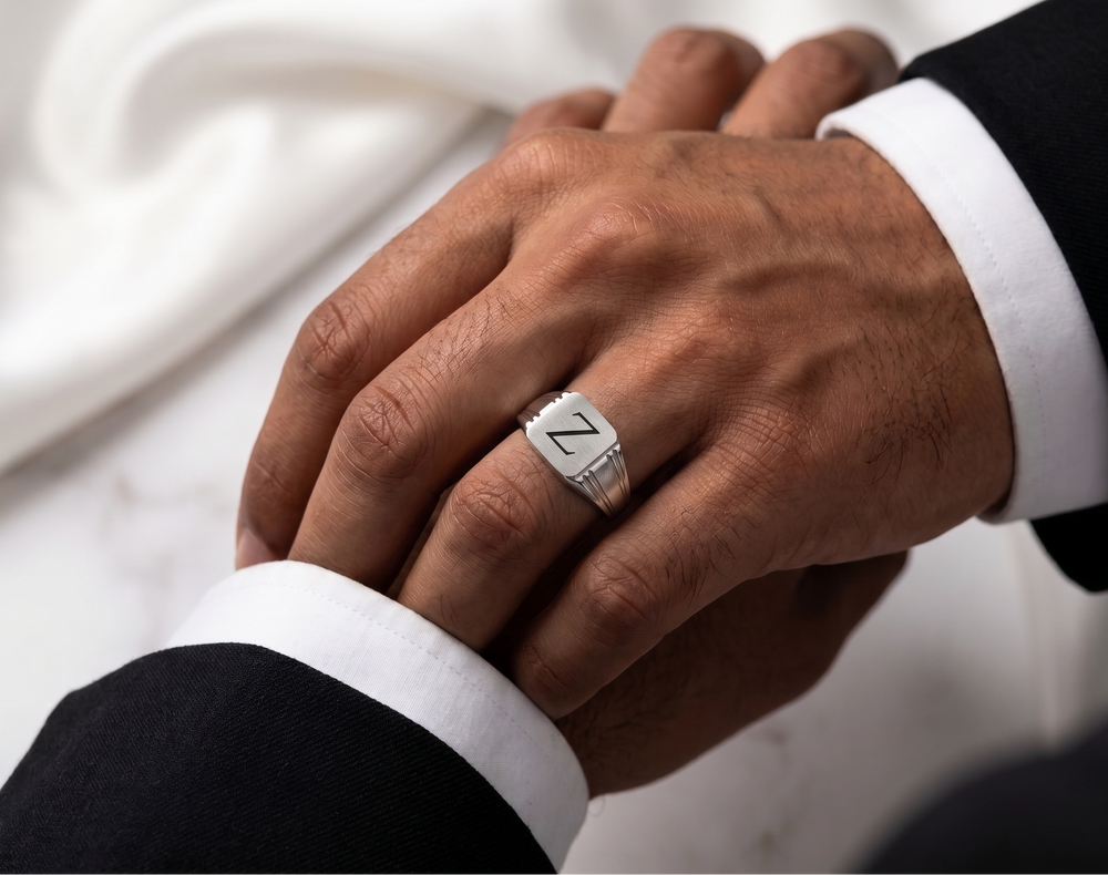 Close-up of a hand wearing a silver ring with a white background