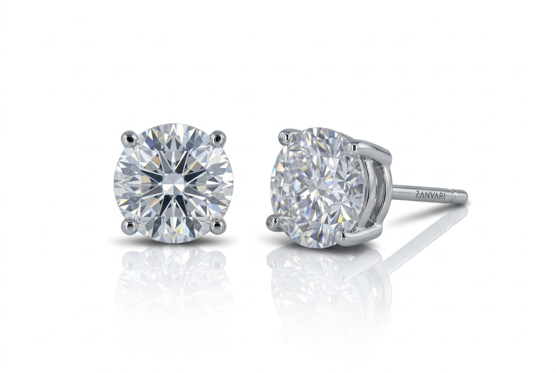 Pair of brilliant round-cut lab-grown diamond stud earrings in a four-prong white gold or platinum setting, displayed against a white background with reflections.