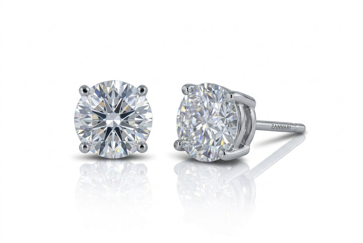 Pair of brilliant round-cut lab-grown diamond stud earrings in a four-prong white gold or platinum setting, displayed against a white background with reflections.