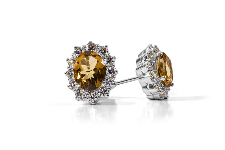A pair of citrine stone stud earrings with rhodium plating and Swarovski zirconia, mounted on sterling silver.